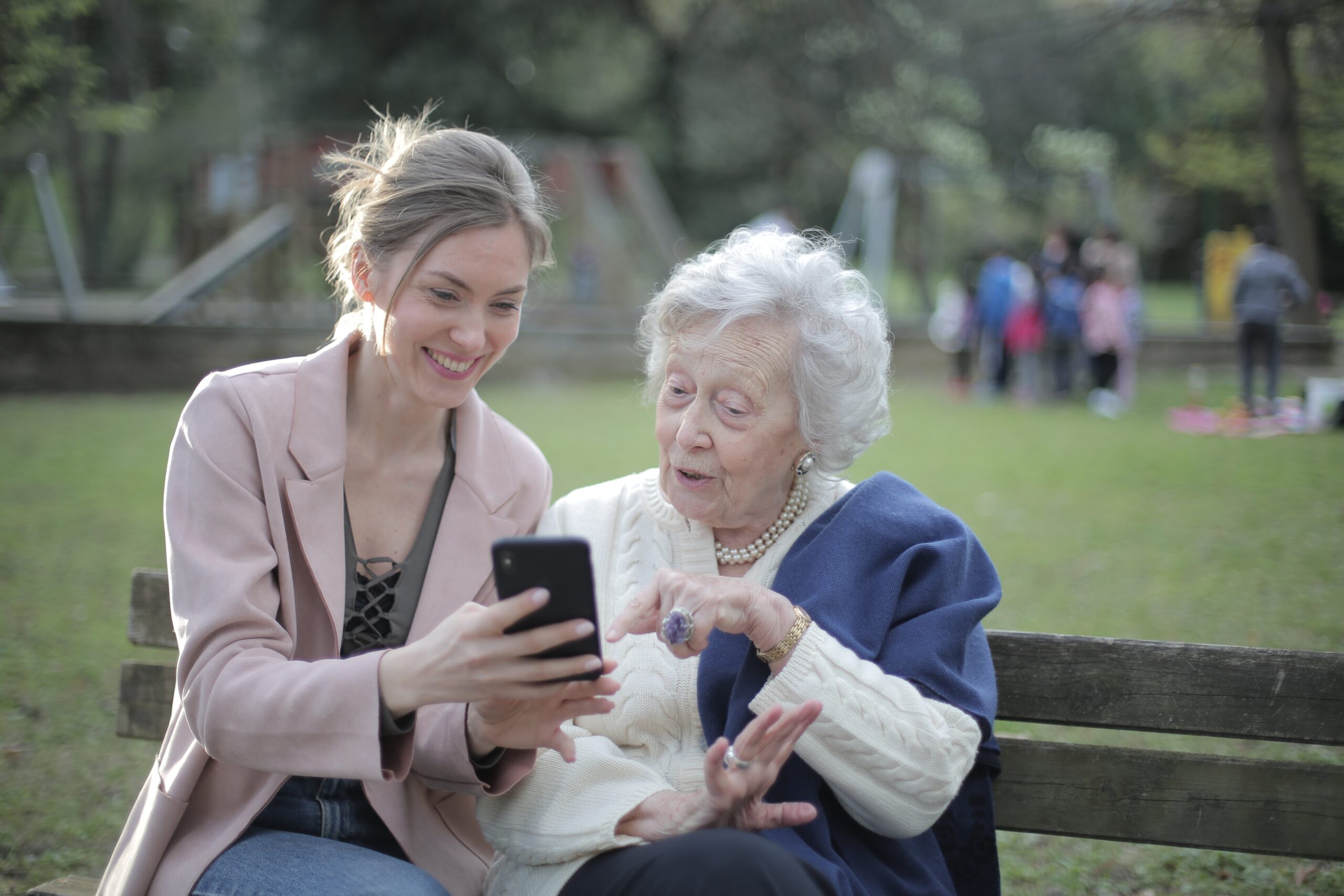 A woman and an old lady looking at something on a phone.