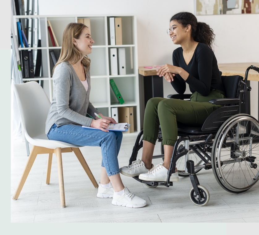 Two women sitting in a room talking to each other.