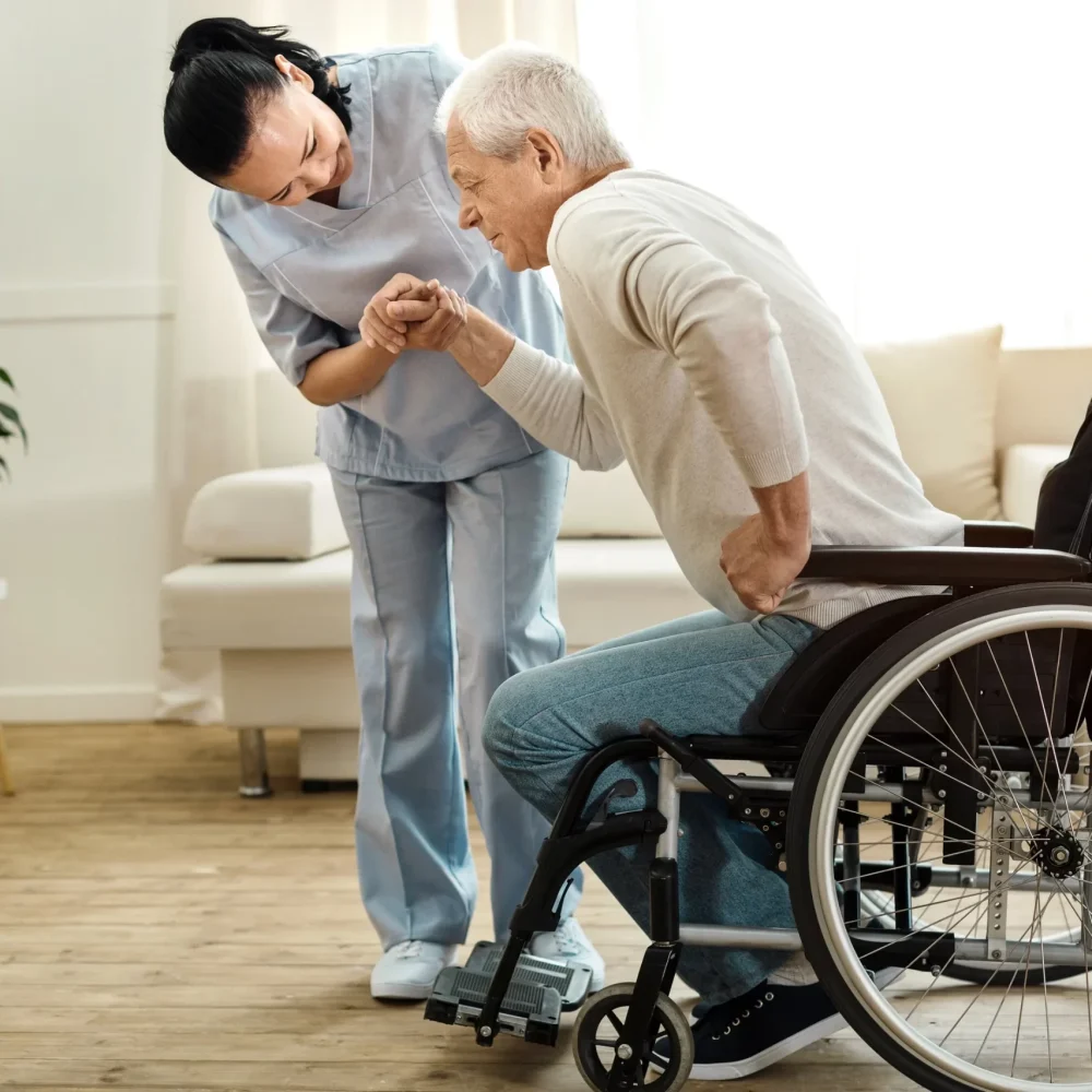 A woman helping an elderly man in a wheelchair.