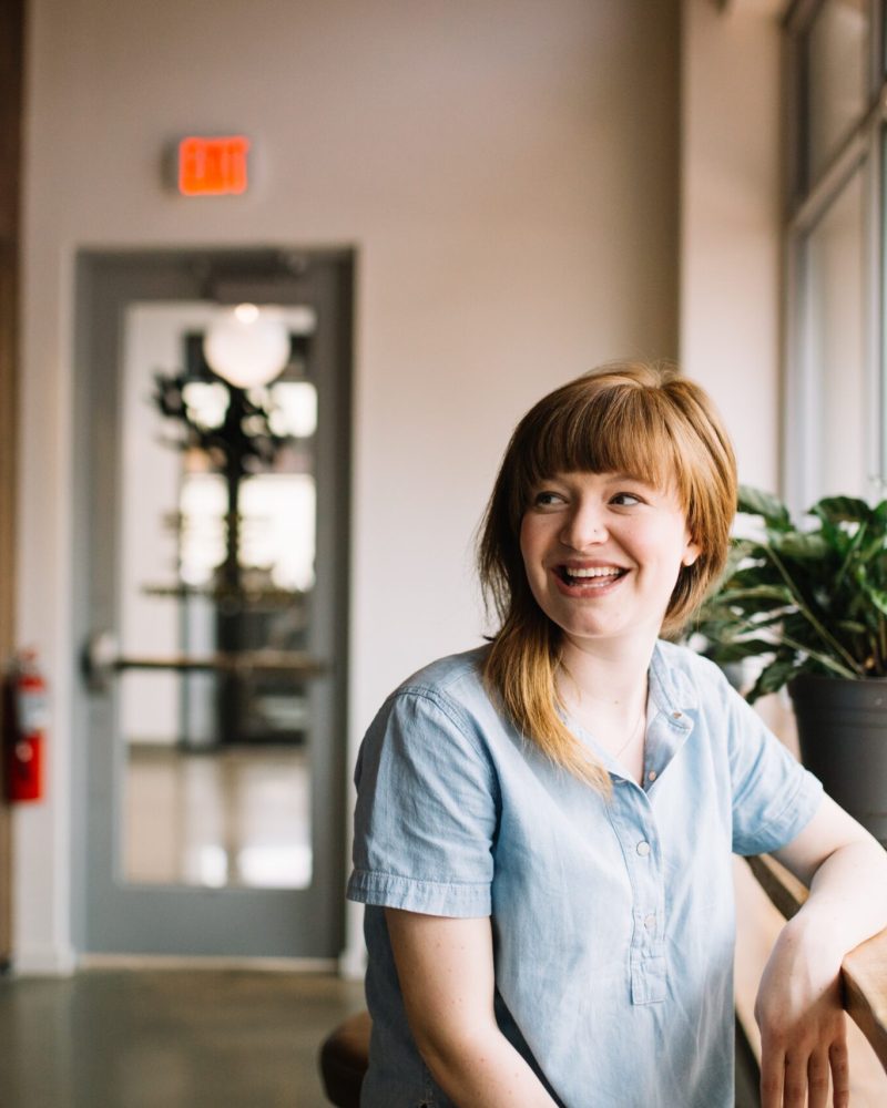 A woman smiling while sitting at the table.